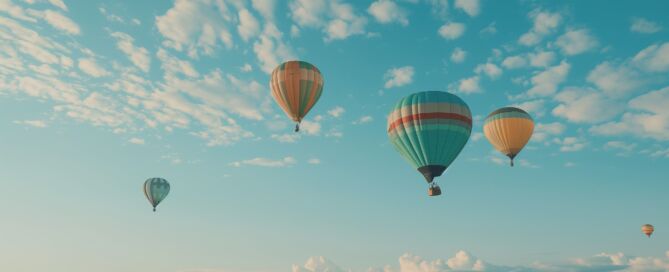 Mehrere Heißluftballons über dem Meer
